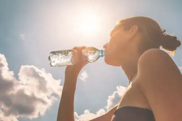 Hydration: The Secret Ingredient for a Toned Stomach and Enhanced Fitness 3 Image of woman drinking water to hydrate Bloxwich after run.