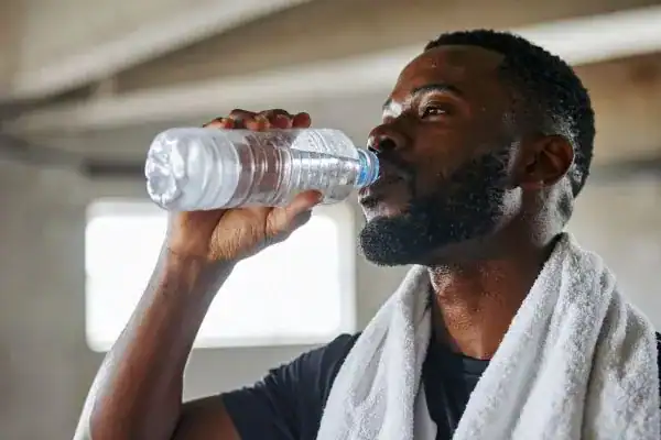 Hydration: The Secret Ingredient for a Toned Stomach and Enhanced Fitness 1 Image of man drinking water to improve hydration Bloxwich after work out.